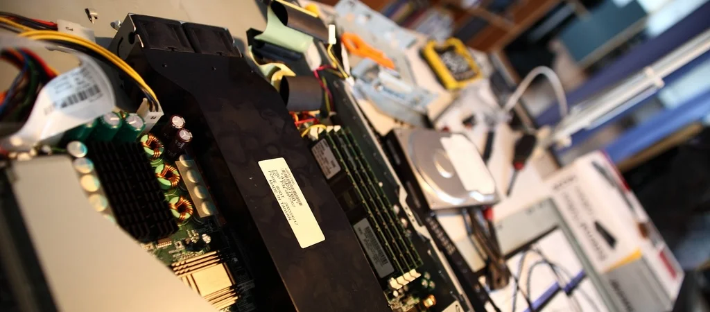 Computer boards and cables on a workbench at Farset Labs