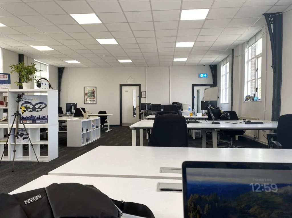 Desks and monitors in the shared workspace at Farset Labs